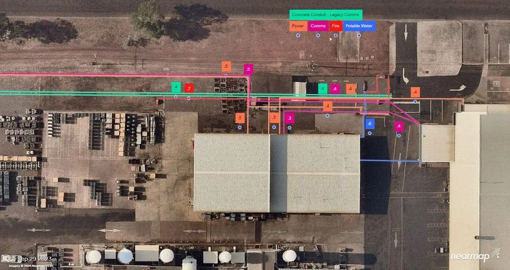 Aerial industrial site with colored utility line overlays