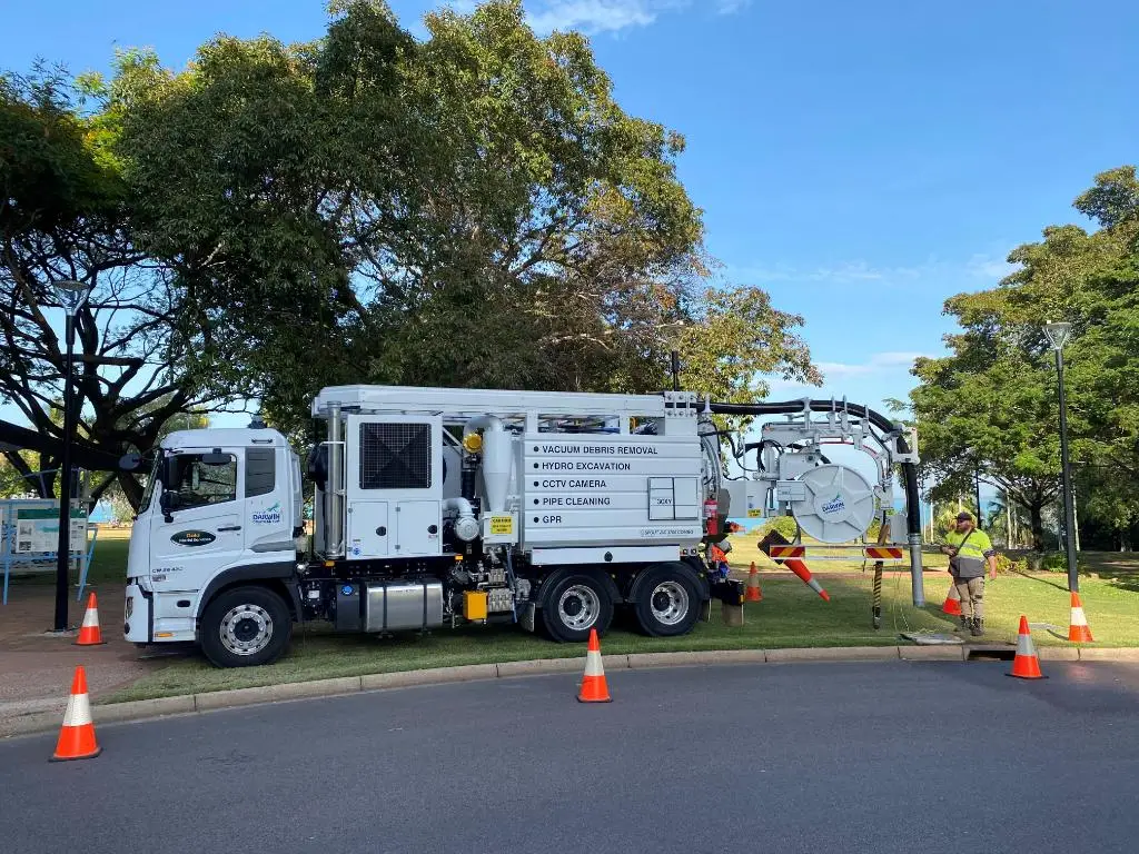 Vacuum excavation truck with workers and traffic cones