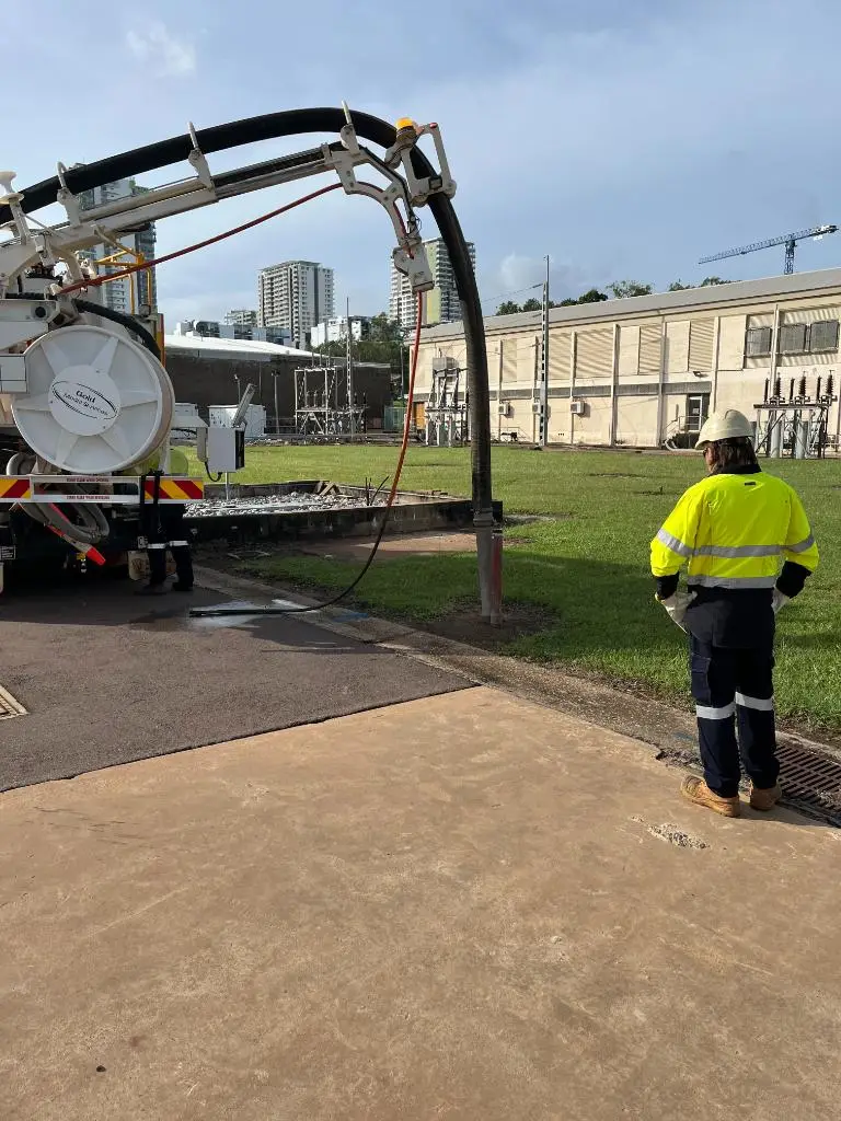 Worker monitoring industrial vacuum truck at utility site