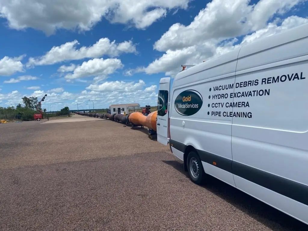 Service van in industrial yard with large pipes