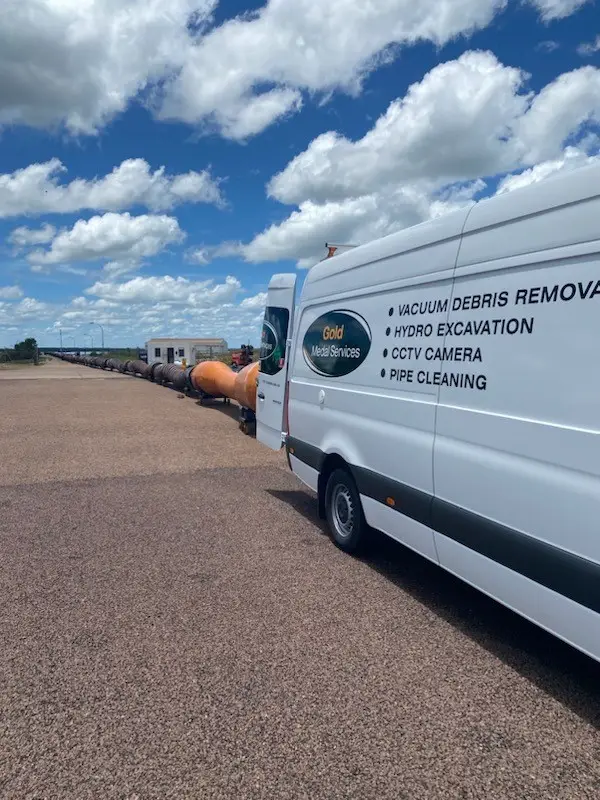 Service van near industrial pipes under blue sky