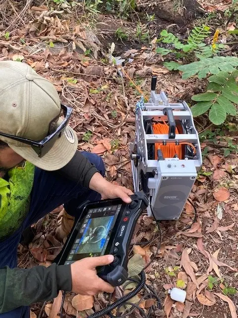 Worker operating remote inspection device in the field