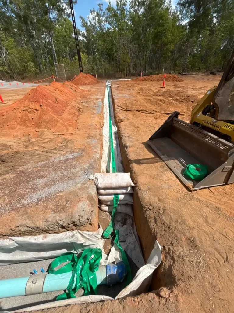 Excavation site with pipes and construction materials.